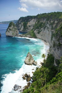 Rock formation by sea against sky