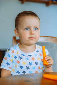 Portrait of cute baby boy sitting on table