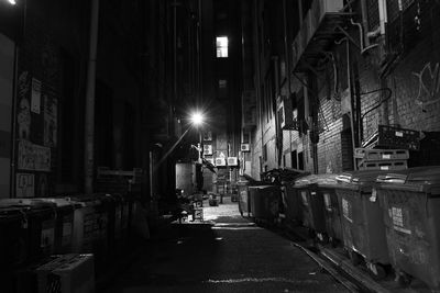 Narrow alley amidst buildings at night