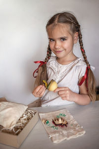 Girl doing craft wrapping for festive gifts with stamp printing technique