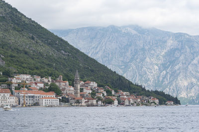 Scenic view of townscape by sea against sky