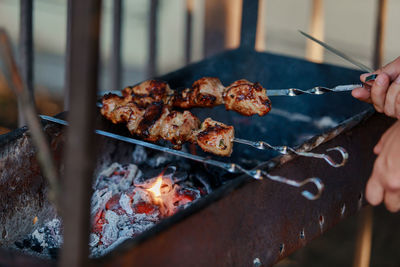 Cropped hand of person cooking food at market stall