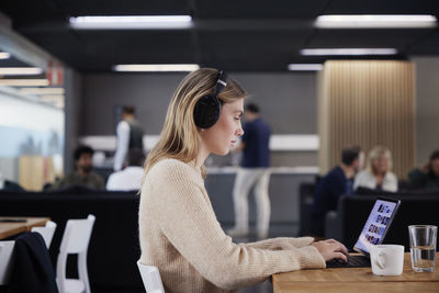 Woman working solitary in office cafeteria