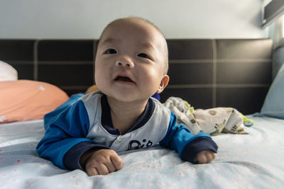 Portrait of cute baby lying on bed