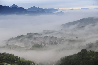 Village in mountains covered with fog