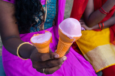 Midsection of woman holding ice cream cone