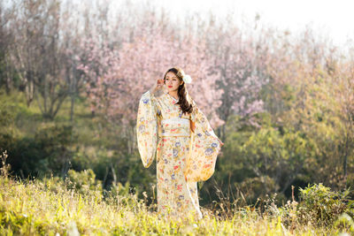 Woman standing by flower tree