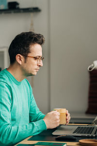 Man looking at camera while sitting on table