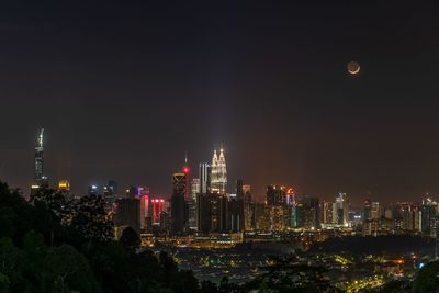 Illuminated buildings against sky at night