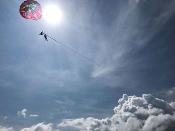 Low angle view of people flying against sky