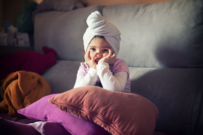 Cute boy sitting on sofa at home