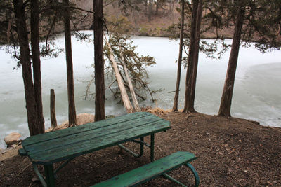 Bench on beach against sky