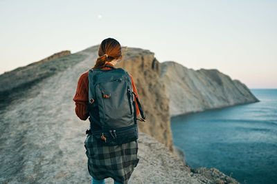 Rear view of woman looking at sea against sky