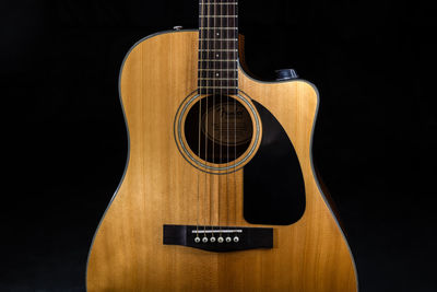 Close-up of guitar against black background