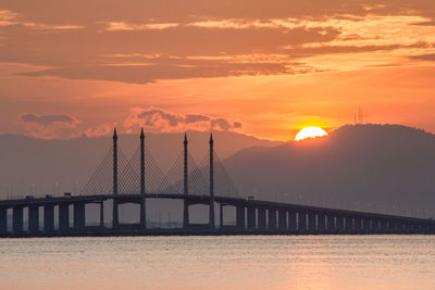 View of suspension bridge against cloudy sky