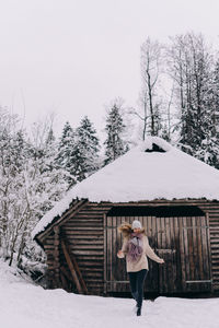 Woman standing on snow covered landscape