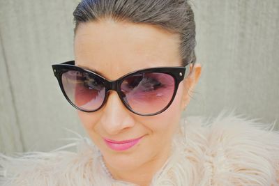 Close-up portrait of smiling woman wearing sunglasses