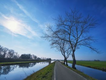 Road by lake against sky