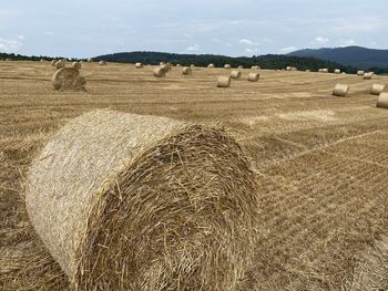 Hay bales on field against sky