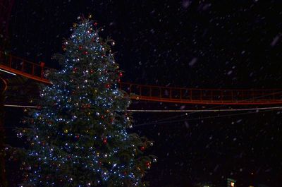 Illuminated christmas lights against sky at night