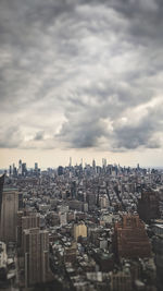 High angle view of city buildings against cloudy sky