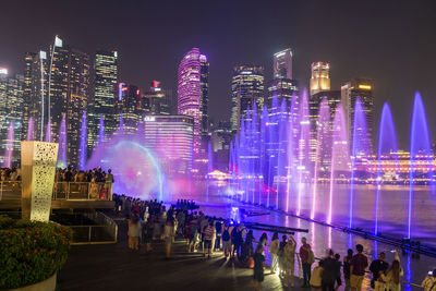 People sightseeing spectra show of dance fountains, light and water show