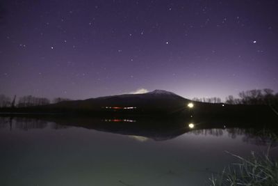 Scenic view of lake against sky at night