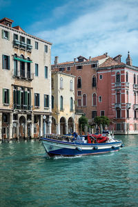 Boats in canal against buildings in city