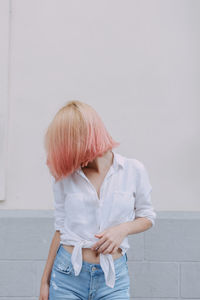 Full length of woman standing against white wall