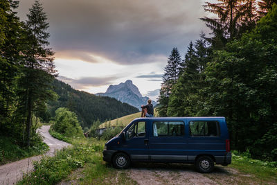 Car on road by mountains against sky