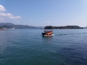 Boat sailing on sea against sky