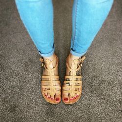 Low section of woman wearing slippers on road