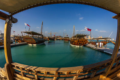 Dhows in katara beach  qatar  with qatar flag daylight with clouds in sky