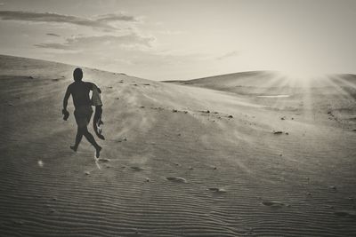 Full length of man on sand at beach against sky