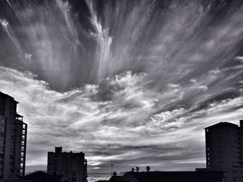 Low angle view of buildings against cloudy sky