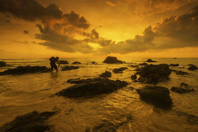 Man standing in sea against sky