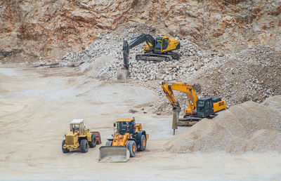 Group of yellow machines working at gravel pit