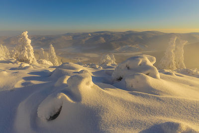 Scenic view of snowcapped mountains against sky during sunset