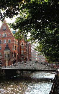 Bridge over river in city against sky