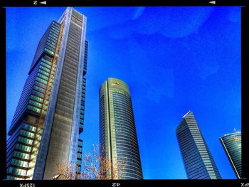 Low angle view of modern buildings against blue sky