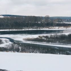 Scenic view of snow covered land against sky