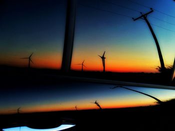 Wind turbines on landscape at sunset