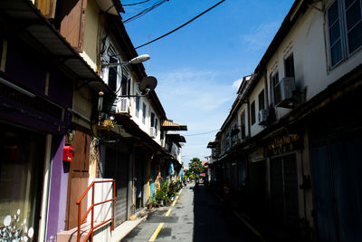 Narrow street amidst buildings against sky