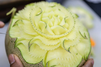 Cropped hand holding carved cantaloupe