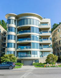 Residential building by road against sky