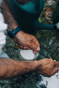 High angle view of man washing paintbrush