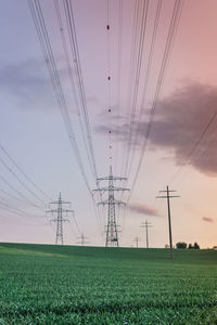 Electricity pylon on field against sky