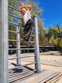 Low angle view of man jumping at home