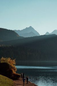 Scenic view of lake and mountains against clear sky