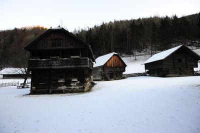 Houses on snow covered landscape against sky